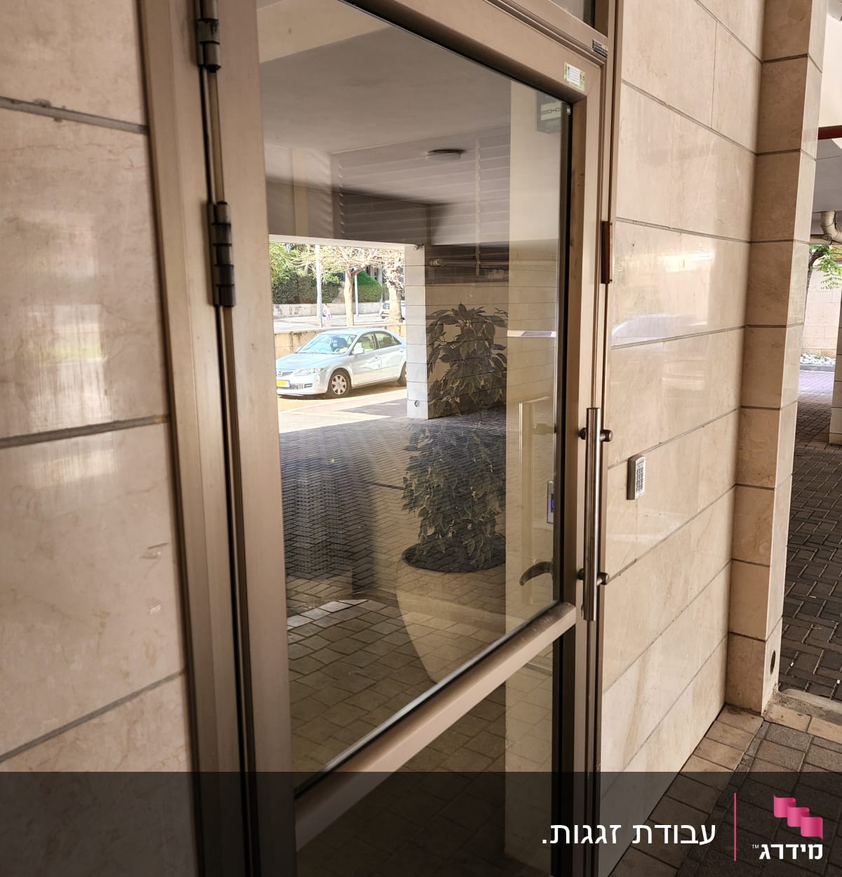 דלת זכוכית עם מסגרת מתכת ליד קיר אבן